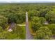 Beautiful aerial view of a quiet street lined with lush trees leading to a charming home surrounded by greenery at 231 Harris Rd, Smithfield, NC 27577
