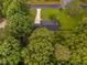 Overhead shot of home nestled among dense trees with a new roof, manicured lawn and ample driveway space visible at 231 Harris Rd, Smithfield, NC 27577