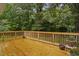Spacious, freshly stained wooden back deck with natural wood railings and serene, wooded views providing privacy at 231 Harris Rd, Smithfield, NC 27577
