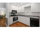 Kitchen with stainless steel appliances, double sink, black dishwasher, and ample lighting at 231 Harris Rd, Smithfield, NC 27577