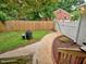 Fenced backyard with a gravel path, grass, a grill, a mulched area, and a patio leading to the house at 2409 Derby Dr, Raleigh, NC 27610