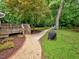 Landscaped backyard featuring a path leading to a deck and fire pit with chairs, perfect for outdoor living at 2409 Derby Dr, Raleigh, NC 27610