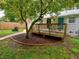 Well-maintained backyard featuring a wooden deck, trees, a grill, and a path leading to a fenced yard at 2409 Derby Dr, Raleigh, NC 27610