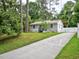 Lovely home featuring a well-maintained lawn, mature trees, a long driveway, and a partial fence at 2409 Derby Dr, Raleigh, NC 27610