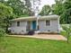 Charming single-story home with gray siding, blue door, updated landscaping, and welcoming curb appeal at 2409 Derby Dr, Raleigh, NC 27610
