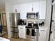 Modern kitchen with stainless steel appliances, white cabinetry, and black hardware for a sleek design at 2409 Derby Dr, Raleigh, NC 27610