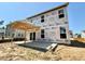 Rear exterior view featuring an unfinished two-story home with a patio, exposed frame, and installed windows at 243 Steel Springs Ln # 25, Angier, NC 27501