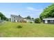 A large fenced backyard with a deck attached to the house and a storage building at 2527 Ossipee Front St, Elon, NC 27244