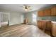 Open kitchen with wood cabinets, white countertops, wood laminate flooring, and natural light at 2527 Ossipee Front St, Elon, NC 27244