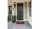 Inviting front porch featuring stone tile, potted plants, and a 'welcome home' doormat at 2656 Welham Aly, Raleigh, NC 27608