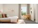Bright bedroom featuring a wooden bed frame, neutral tones, and a sunny window with a chair at 2924 Ocean Sunrise Dr, Wake Forest, NC 27587