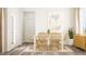 Elegant dining room with a white table, wicker chairs, and a stylish sideboard, creating a perfect setting for Gathering meals at 2924 Ocean Sunrise Dr, Wake Forest, NC 27587