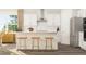 Bright kitchen featuring white cabinets, stainless steel appliances, and a breakfast bar with stylish stools, perfect for casual dining at 2924 Ocean Sunrise Dr, Wake Forest, NC 27587