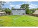 View of the backyard and back of the home showing a large yard with wood fence at 3306 Woodland Park Rd, Durham, NC 27703