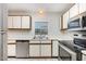 Bright kitchen with white cabinets and stainless steel appliances, and updated countertops at 3306 Woodland Park Rd, Durham, NC 27703