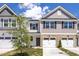 Exterior view of townhomes with attached garages, stone accents, and professionally landscaped front yard at 3916 Well Fleet Dr, Fuquay Varina, NC 27526