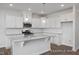 Modern kitchen features white cabinets, granite countertops, stainless steel appliances, and an island at 3916 Well Fleet Dr, Fuquay Varina, NC 27526