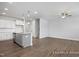 Modern kitchen with white cabinets, granite countertops, and hardwood floors throughout open space at 3916 Well Fleet Dr, Fuquay Varina, NC 27526