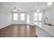Open concept living room with hardwood floors, ceiling fan, and natural light streaming in from large windows at 3916 Well Fleet Dr, Fuquay Varina, NC 27526