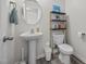 Stylish bathroom featuring a pedestal sink, round mirror, and modern toilet at 4097 Cordiality Church Rd, Nashville, NC 27856