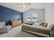 Cozy bedroom with decorative blue accent wall, complemented by a comfortable bed and bright windows at 4097 Cordiality Church Rd, Nashville, NC 27856