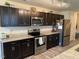 Modern kitchen featuring dark wood cabinets, stainless steel appliances, and granite countertops at 4097 Cordiality Church Rd, Nashville, NC 27856