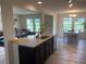 Kitchen island with granite countertops, dark wood cabinets, and open layout to dining and living areas at 4097 Cordiality Church Rd, Nashville, NC 27856