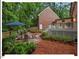 Landscaped backyard featuring a patio area, wooden fence, and lush green trees for privacy at 45 Birnham Ln, Durham, NC 27707