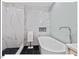 Bathroom boasts a modern soaker tub, white marble tile, and elegant fixtures, creating a relaxing retreat at 45 Birnham Ln, Durham, NC 27707
