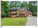 Beautiful brick home featuring an attached garage, basketball hoop, and surrounded by lush greenery at 45 Birnham Ln, Durham, NC 27707