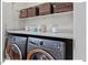 Convenient laundry area with modern washer and dryer, ample counter space, and upper shelves for storage at 45 Birnham Ln, Durham, NC 27707