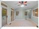 Light-filled sunroom showcasing tile floors, modern ceiling fan, and access to outdoor spaces at 45 Birnham Ln, Durham, NC 27707