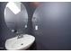 Modern powder room with a sleek sink and a stylish round mirror at 4807 Landover Charge Ln, Raleigh, NC 27616
