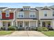 Attractive townhome featuring a welcoming porch, manicured shrubs, and classic facade under a bright, sunny sky at 4807 Landover Charge Ln, Raleigh, NC 27616