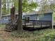 Spacious wooden deck with stairs connects to a charming blue house, surrounded by lush trees at 507 Holtz Ln, Cary, NC 27511