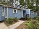 Beautiful blue home surrounded by nature, showcasing its unique design and well-maintained landscaping at 507 Holtz Ln, Cary, NC 27511