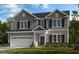 Charming two-story home boasts gray siding, attached garage and well-maintained landscaping at 515 Claftin St, Sanford, NC 27330