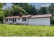 Charming home featuring a red metal roof, white exterior, and lush green lawn at 519 W Raleigh St, Siler City, NC 27344