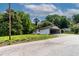 View of charming one-story home with white siding, red roof, and a connected carport on a grassy lot at 519 W Raleigh St, Siler City, NC 27344