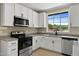 Well-lit kitchen featuring stainless steel appliances and granite countertops at 519 W Raleigh St, Siler City, NC 27344