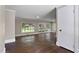 Living room featuring wood floors, paneled walls, multiple windows, and French doors leading to the backyard at 519 W Raleigh St, Siler City, NC 27344
