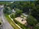 Aerial image of a colorful neighborhood playground with swings, slides, and climbing structures, surrounded by trees at 519 W Raleigh St, Siler City, NC 27344