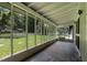 Covered porch with stone flooring and screened windows overlooking the yard at 519 W Raleigh St, Siler City, NC 27344