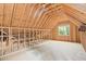 Spacious attic with exposed wood beams, framing, and a window offering natural light at 5233 Greymoss Ln, Apex, NC 27539