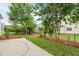 Well-maintained backyard featuring manicured landscaping and a concrete patio area at 5233 Greymoss Ln, Apex, NC 27539