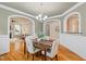 Traditional dining room with decorative wainscoting, modern chandelier, and hardwood flooring at 5233 Greymoss Ln, Apex, NC 27539