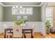Bright dining room with decorative wainscoting and classic chandelier fixture above table setting at 5233 Greymoss Ln, Apex, NC 27539