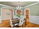 Charming dining room with stylish lighting fixture and arched entryways to kitchen and living spaces at 5233 Greymoss Ln, Apex, NC 27539