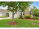 Landscaped front yard with mature tree and stone chimney on a charming home exterior at 5233 Greymoss Ln, Apex, NC 27539