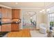 View of the kitchen and adjoining sitting area and office space with lots of light and wooden cabinets at 5233 Greymoss Ln, Apex, NC 27539